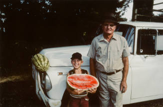 Unidentified watermelon vendor and son, betcheimer Store, Highway 27, Utica, Mississippi, 1974